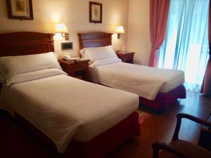 a hotel room with two beds and a window at Hostal Bahía in San Sebastián