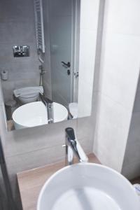 ein Badezimmer mit einem Waschbecken, einem WC und einem Spiegel in der Unterkunft Be based near Acropolis, in an exquisite studio! in Athen