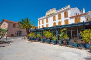 un bâtiment avec des plantes en pot devant lui dans l'établissement Hotel Restaurant La Villa Arena, à Carry-le-Rouet