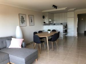a living room with a couch and a table and chairs at Ruim 3 slaapkamerappartement vlakbij het strand in Koksijde
