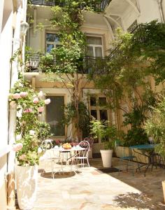 une terrasse avec une table et des chaises devant un bâtiment dans l'établissement Hôtel Henri IV, à Tarbes