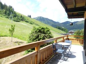 uma varanda com uma mesa e cadeiras e uma montanha em Ty Menez 2 - Chalet sur les pistes em La Clusaz