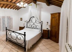 una camera con letto e testiera in ferro battuto di Villa di Papiano a San Baronto