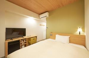 Postel nebo postele na pokoji v ubytování Sotetsu Fresa Inn Tokyo Tamachi