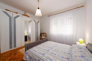 a bedroom with a bed and a large window at Apartment Nigra in Lovran