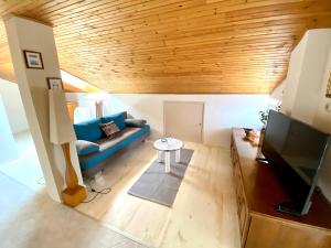 a living room with a blue couch and a table at Guesthouse Kurelic Rab in Kampor
