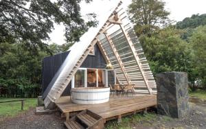a tiny house with a tub on a wooden deck at Termas de Aguas Calientes in Puyehue