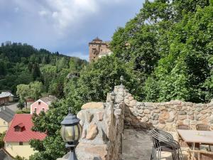 una pared de piedra con un castillo en el fondo en Penzion - Restaurant U Zámku en Bečov nad Teplou