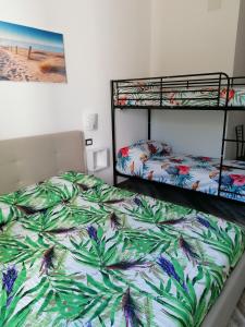 聖塔瑪麗亞拉帕爾瑪的住宿－Il Patio Alghero，一间卧室配有两张双层床和一幅画