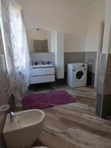 uma casa de banho com um lavatório e uma máquina de lavar roupa em Il Patio Alghero em Santa Maria la Palma