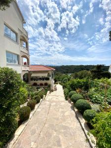 a walkway leading to a house with a garden at Guesthouse Kurelic Rab in Kampor