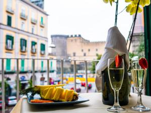 a plate of food and a glass of wine on a table at San Marco Hotel in Naples