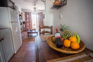 un cesto di frutta e una bottiglia di vino su un tavolo di La Casita De Ana a Jimena de la Frontera