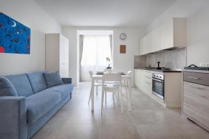 a living room with a blue couch and a kitchen at LA ROCCA SUITE in Garda +11 photos