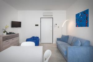 a living room with a blue couch and a table at LA ROCCA SUITE in Garda