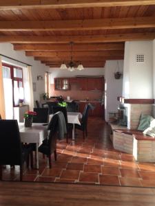 a dining room with tables and chairs and a kitchen at Dósa tanya, Vendégház in Cserépfalu