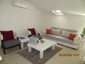 a living room with a couch and two chairs and a table at Stella City Apartments in Fethiye