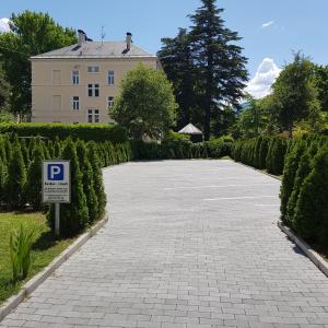eine Einfahrt mit einem Parkschild vor einem Gebäude in der Unterkunft Garni Villa Tyrol - Adults Only in Meran