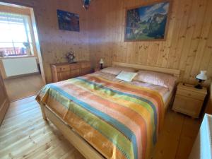 een slaapkamer met een bed in een houten kamer bij Luxusní horský apartmán v Beskydech in Malenovice