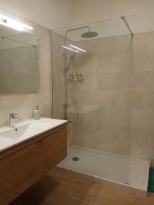 La salle de bains est pourvue d'une douche, d'un lavabo et d'une baignoire. dans l'établissement ALMA Flat in Olhão, à Olhão
