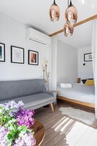 1 dormitorio con sofá, mesa y flores en SEAVIEW - A Special Place For Two en Palanga