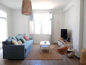 uma sala de estar com um sofá azul e uma mesa em ALMA Flat in Olhão em Olhão