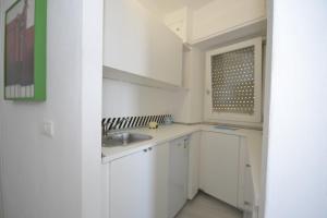cocina blanca con fregadero y ventana en Casa Pinuccia guest house, en Rosolini