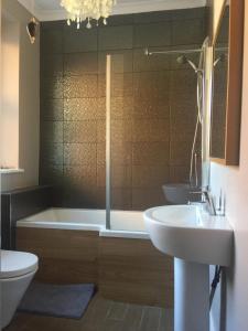een badkamer met een bad, een toilet en een wastafel bij Collingwood House Tynemouth in Tynemouth
