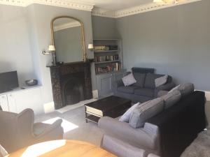 a living room with a couch and a mirror at Collingwood House Tynemouth in Tynemouth