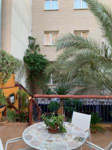 een patio met een tafel en stoelen en een gebouw bij El Camí Hotel in Cambrils