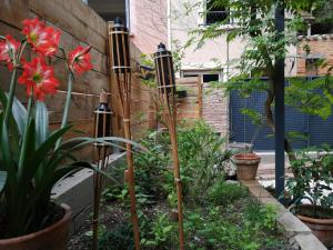 - un jardin avec des fleurs et des bâtons de bambou dans l'établissement Gîte bord du Tarn, à Gaillac