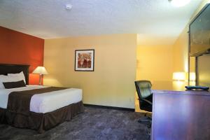 ein Hotelzimmer mit einem Bett und einem Schreibtisch in der Unterkunft McMinnville Inn in McMinnville + 4 Fotos