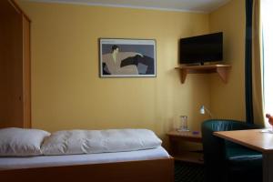 ルクセンブルクにあるAu P'tit Max - Studios hotelのベッドと薄型テレビがあるホテルの部屋 +13枚の写真