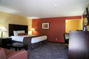 ein Hotelzimmer mit einem Bett und einem Stuhl in der Unterkunft McMinnville Inn in McMinnville