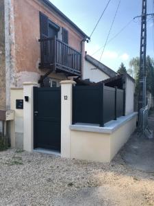 una puerta negra delante de una casa en Féricy, en Féricy
