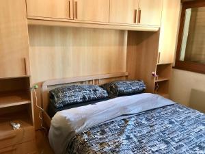 ein Schlafzimmer mit einem Bett mit zwei Kissen darauf in der Unterkunft Appartamento chalet in Laax