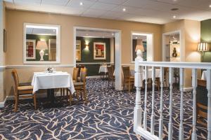 a dining room with a table and chairs at Wycliffe Hotel in Stockport