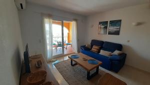 een woonkamer met een blauwe bank en een tafel bij Duplex Mandala 2 Moraira in Benitachell