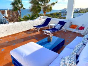 een patio met blauwe en witte meubels en de oceaan bij PLAYA PALOMA Beach House 8PAX in Estepona