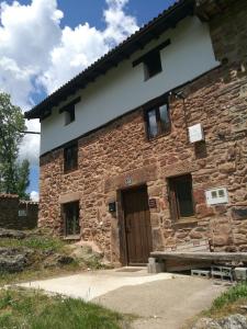 ein Steingebäude mit einer braunen Tür und Fenstern in der Unterkunft Casa Soleta Ezcaray in Ezcaray