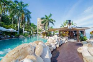 a pool at a resort with rocks in the water at Garza Blanca Preserve Resort & Spa in Puerto Vallarta