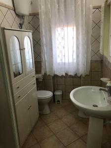 a bathroom with a sink and a toilet and a window at Le stanze dell'Olimpo in Agrigento