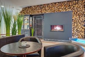 a room with a table and chairs and a fireplace at Hotel Stadt Mühlhausen in Mühlhausen