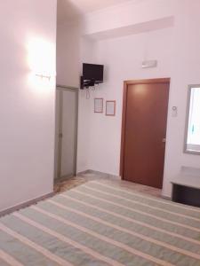 Pokój z drzwiami i telewizorem na ścianie w obiekcie Gioia Guest House w Rzymie