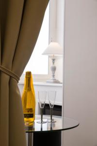 a bottle of champagne and two glasses on a table at Royal Rooms Luxury Suite in Naples