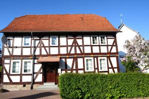 biało-brązowy budynek z czerwonym dachem w obiekcie #Hoenepartment - TimeOut Waldhessen - bis zu 8 Pers. w mieście Hönebach