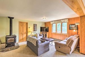 sala de estar con sofá y estufa de leña en Scenic Forest Lodge Outside Glacier National Park!, en West Glacier