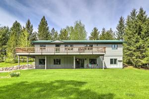 una casa grande con terraza en la parte superior de un patio en Scenic Forest Lodge Outside Glacier National Park!, en West Glacier