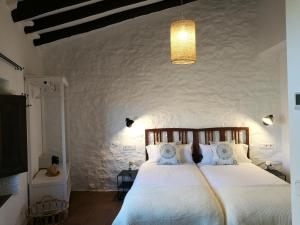 1 dormitorio con 1 cama grande y pared en Hostal Blavet en Calaceite