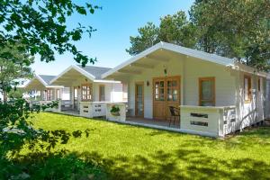 a small white house with a yard at Marina Holiday in Ustka